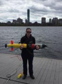 Erin Fischell ’10 holds an autonomous underwater vehicle used for research at the Woods Hole Oceanographic Institution.