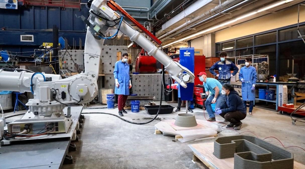 researchers work with large robotic arm