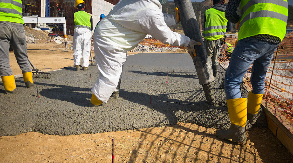 construction workers pour cement