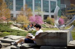 A student studies near the Pew Sundial on the Engineering Quad in spring.