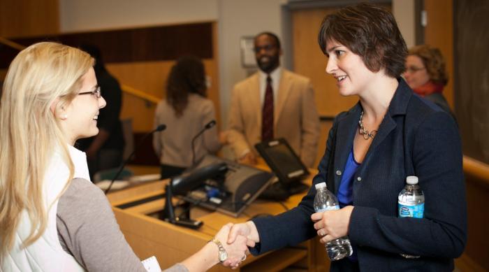 Student shaking alumni hand at event